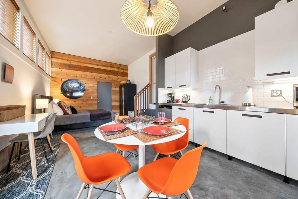 A bright, modern space where your vacation days begin. Enjoy meals at the vibrant dining table, cook in your fully equipped kitchen, and unwind in the cozy living area beneath vaulted ceilings.