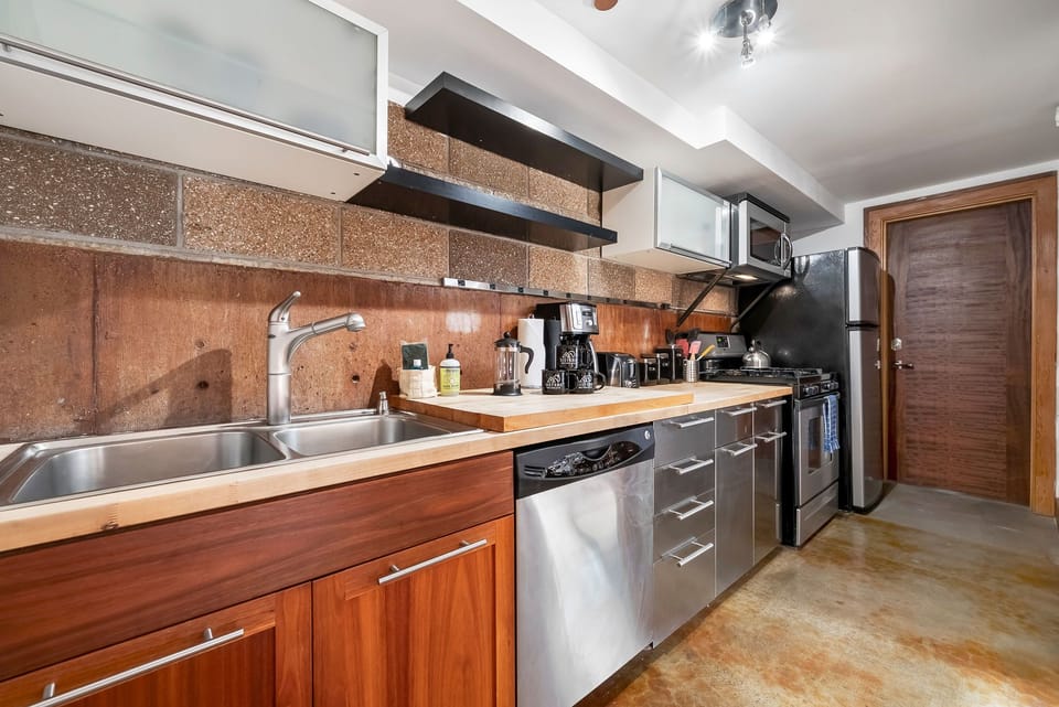 A well-equipped kitchen with modern stainless steel appliances, warm wood cabinetry, and plenty of counter space for all your culinary needs during your stay.