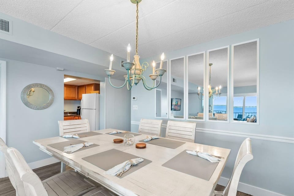 This view highlights the excellent flow of the home, connecting the dining space with the kitchen and mirrored wall accents.