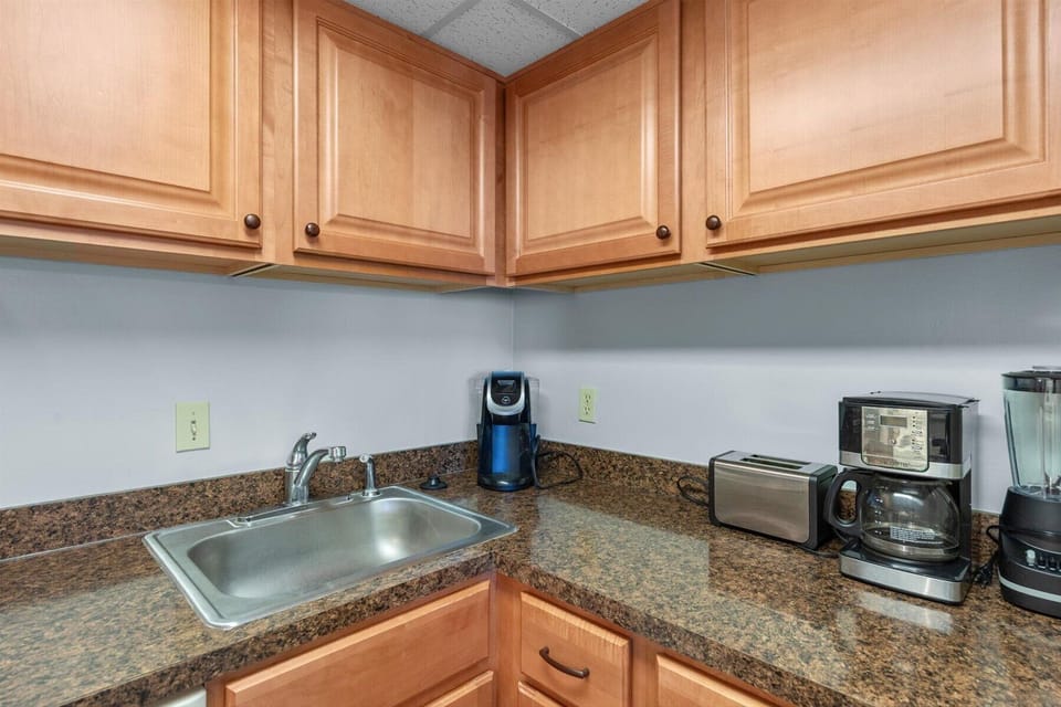 Enjoy your morning routine with convenient counter space featuring a dual-basin sink, toaster, and coffee maker.