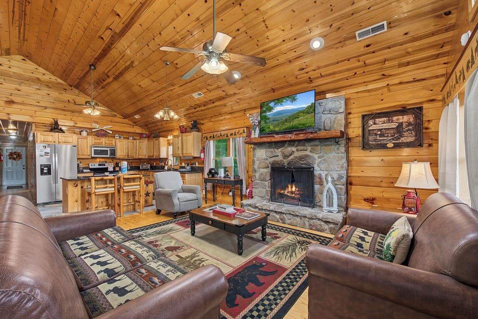 Gather around the stone fireplace in this warm, open-plan cabin retreat. Vaulted wood ceilings, a fully-equipped kitchen, and cozy leather seating invite relaxation after a day exploring the mountains.