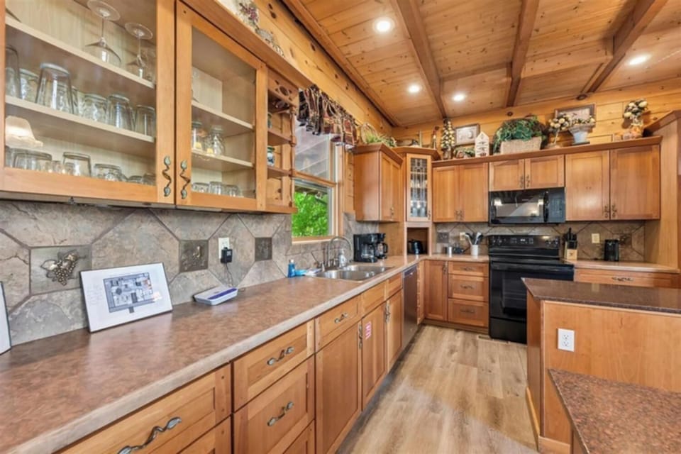 Your fully equipped kitchen features warm wood cabinetry, granite countertops, modern appliances, and rustic vaulted ceilings—perfect for preparing home-cooked meals and gathering with loved ones.