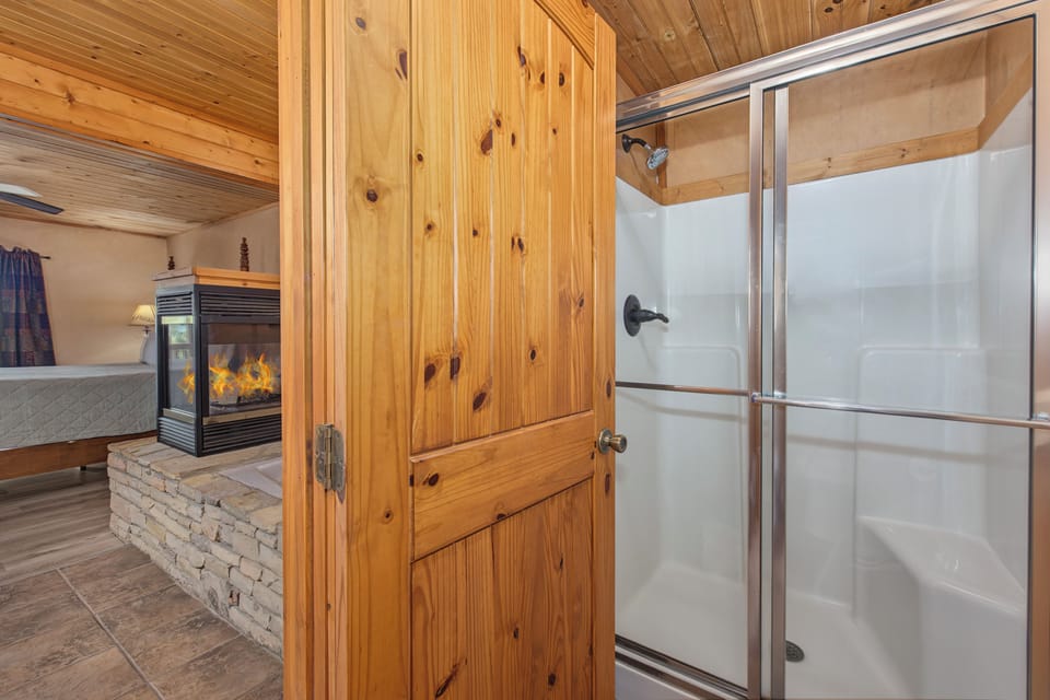 Freshen up in your private bathroom featuring a walk-in shower, wooden accents, and plenty of natural light to start your day right.