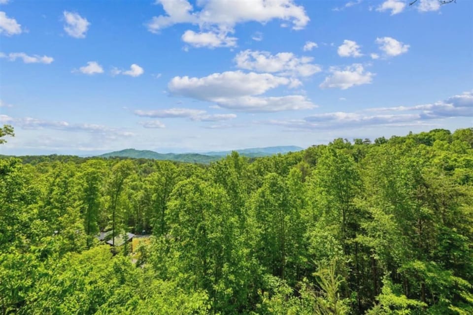 Nestled in lush forested mountains, this secluded retreat offers peaceful natural surroundings and scenic mountain views, captured on a beautiful summer day.