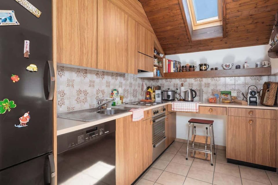 Fully equipped kitchen with stove, oven, refrigerator, coffee machine, and dining counter.