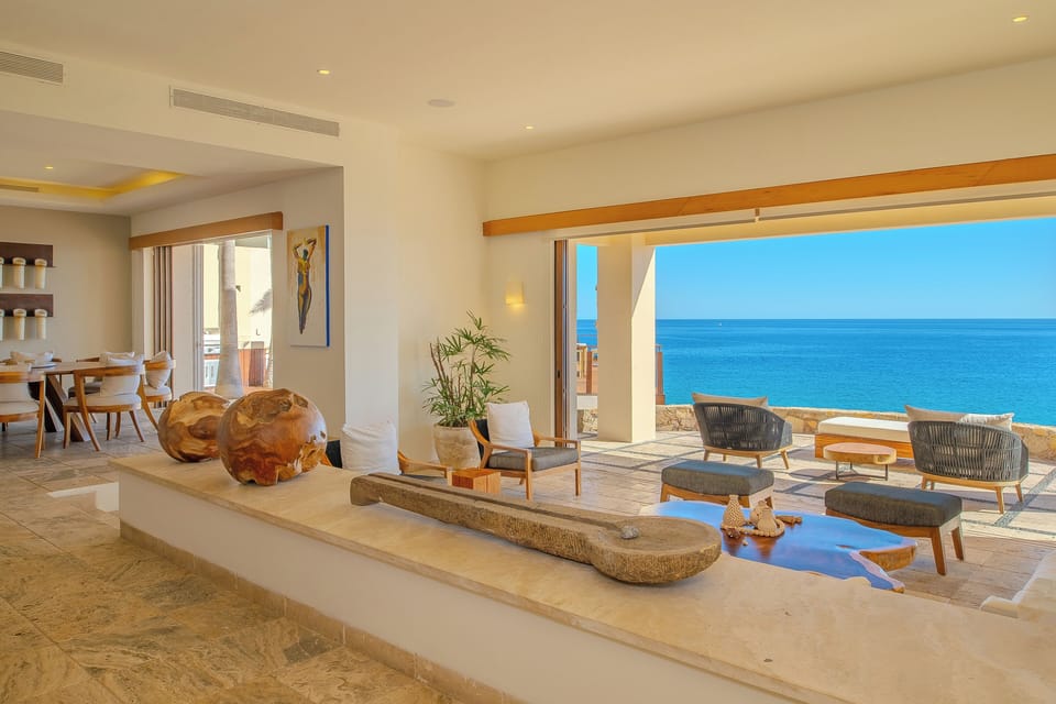 Sunlight streams through your living space, framing stunning ocean views that stretch endlessly beyond the terrace. Natural textures and warm woods create an inviting sanctuary where relaxation feels effortless.