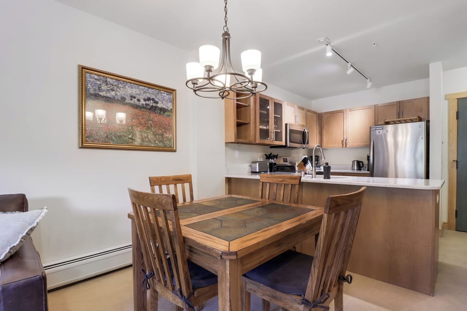 Gather around the dining table in your open-concept space, where warm wood tones and modern conveniences create the perfect setting for memorable meals and morning coffee together.