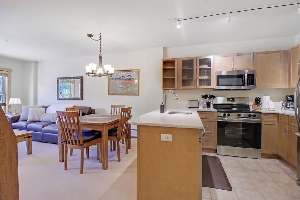 Your open-concept space flows seamlessly from a fully equipped kitchen to a welcoming dining area and cozy living room—perfect for memorable meals and relaxed evenings together.