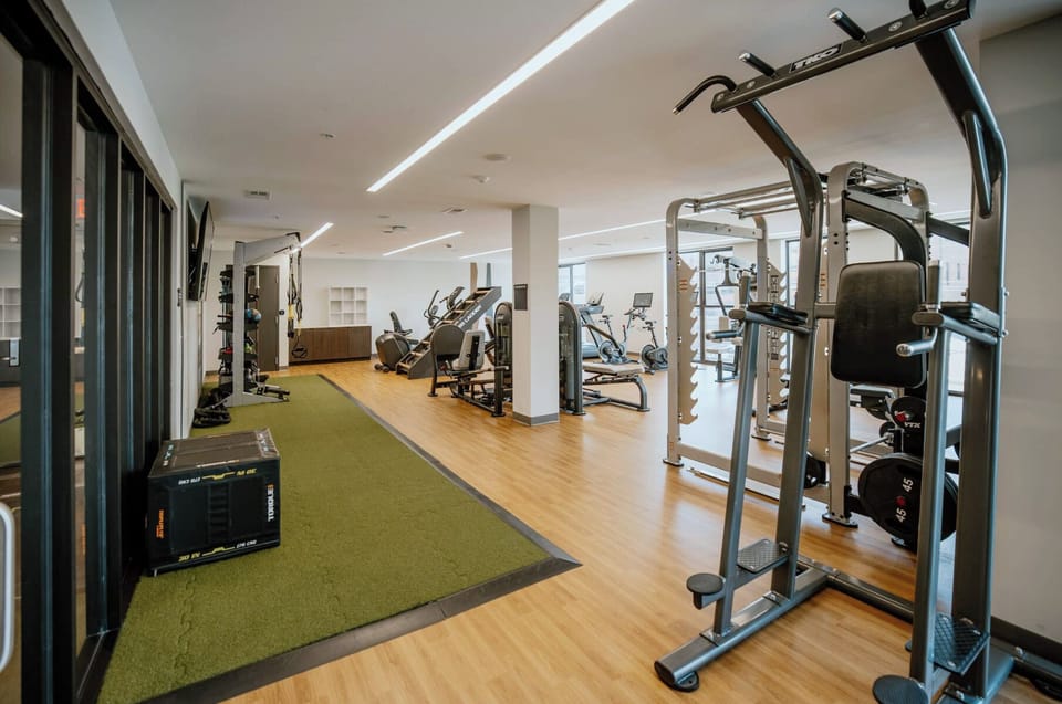 Bright, fully equipped fitness center with cardio, weights, and turf area