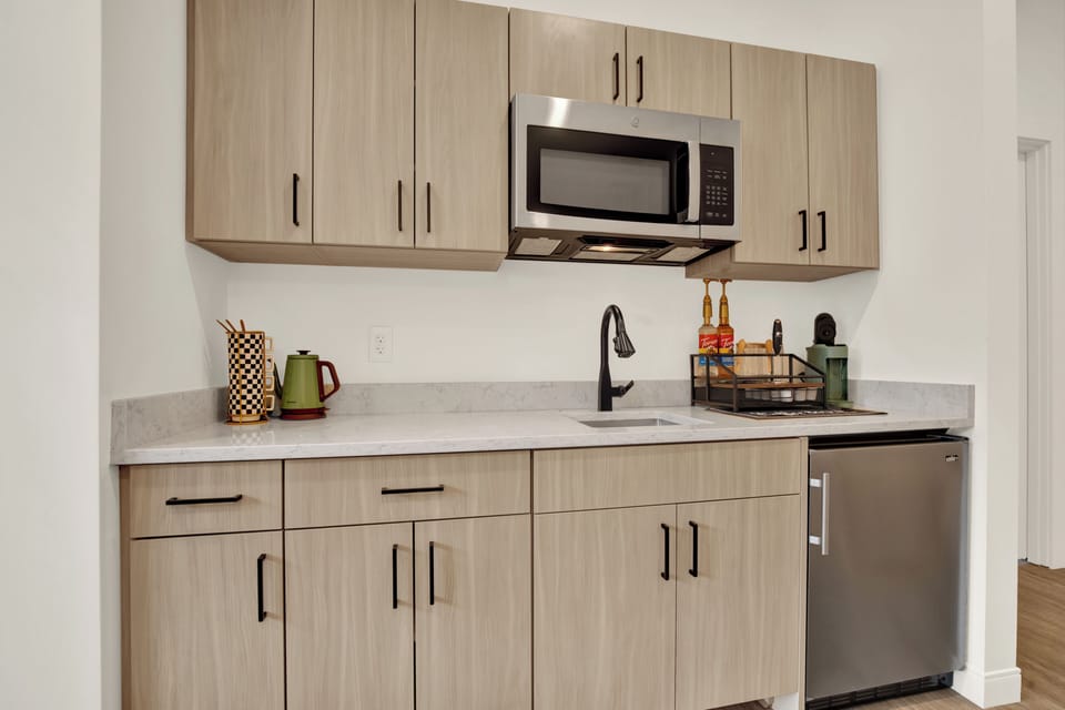Modern kitchenette with stainless appliances and stylish finishes