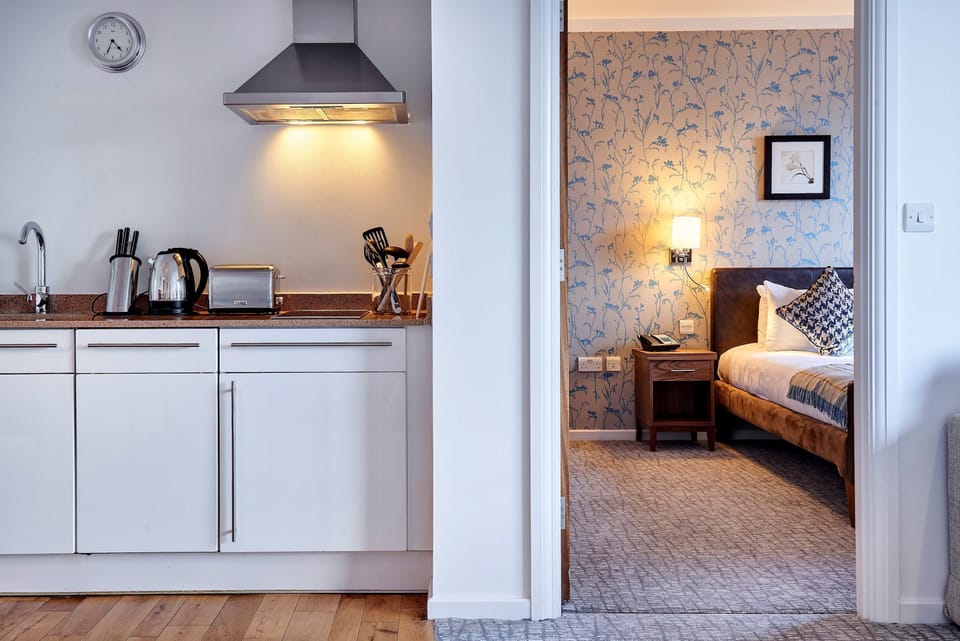 Kitchen area with modern appliances and adjacent bedroom view.