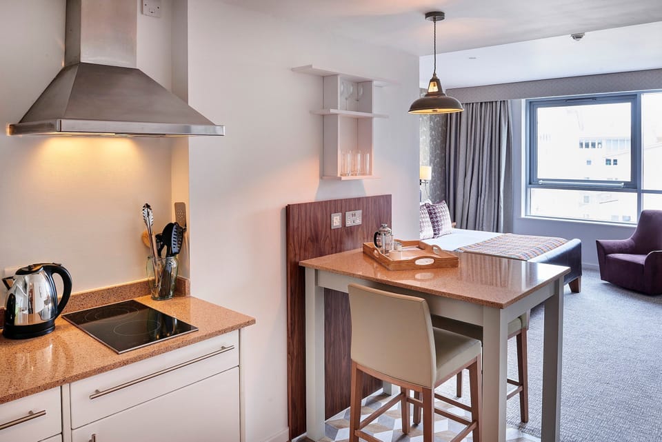 Kitchen outfitted with essential appliances and casual dining bar.