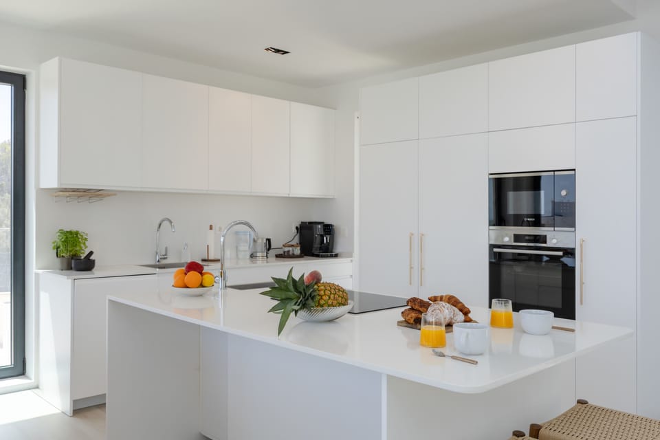 Modern kitchen with sleek white cabinetry and a spacious island for casual dining.