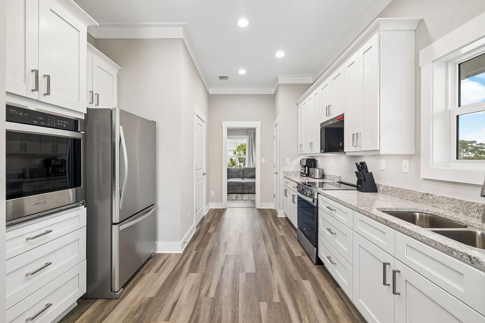 Your gourmet kitchen awaits with gleaming granite counters, stainless appliances, and crisp white cabinetry—perfect for morning coffee or family feasts.