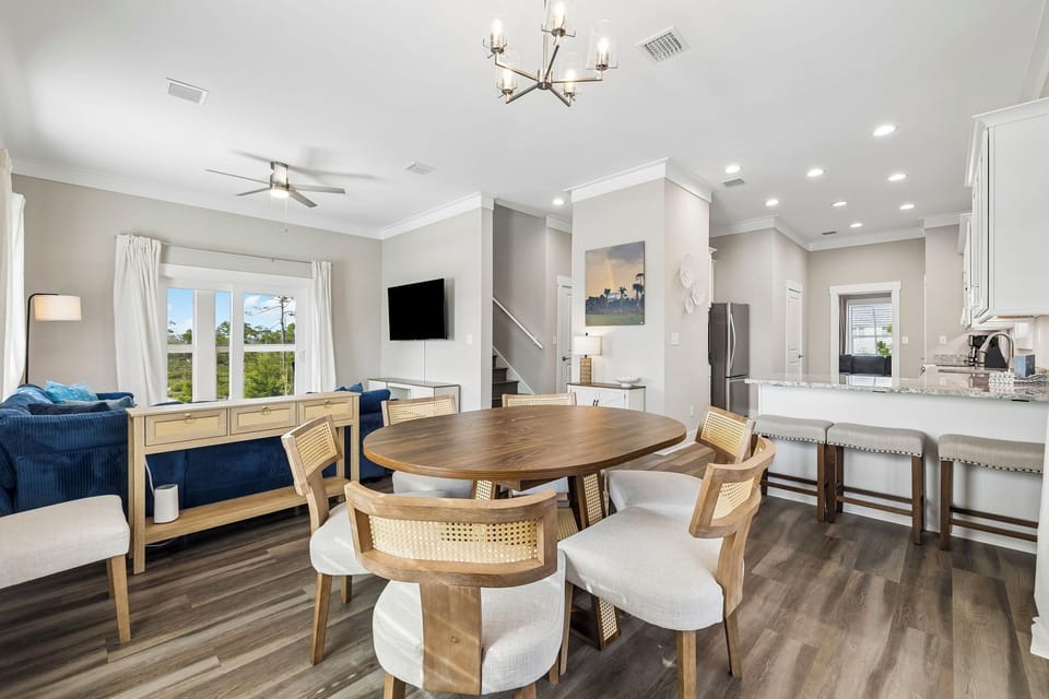 Your open-concept living and dining area welcomes you with bright natural light, modern coastal touches, and a spacious layout perfect for gathering over meals or relaxing together.