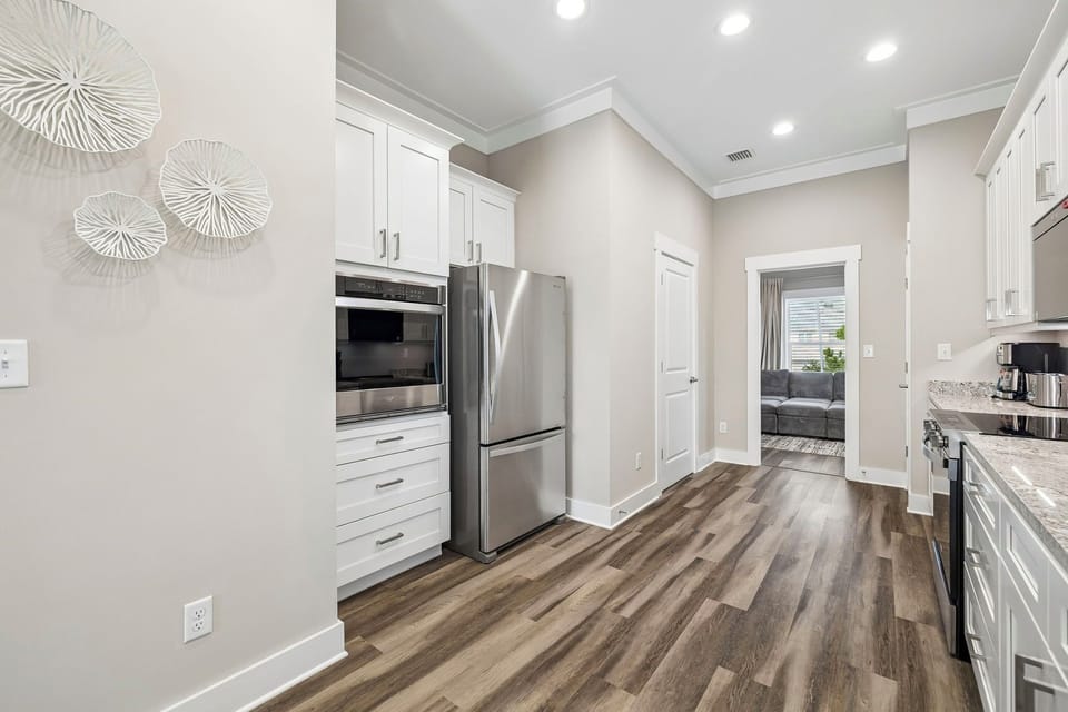Step into your bright, modern kitchen featuring stainless steel appliances, spacious cabinetry, and elegant wood-style flooring—perfect for preparing meals and gathering with loved ones.