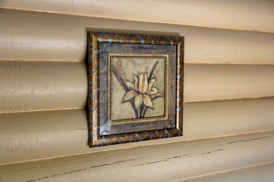 A small framed floral artwork adds a gentle decorative accent to the bedroom wall.