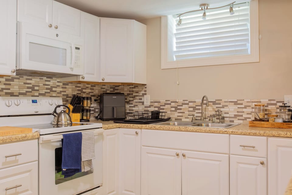 Bright, fully equipped kitchen with stylish backsplash and natural light