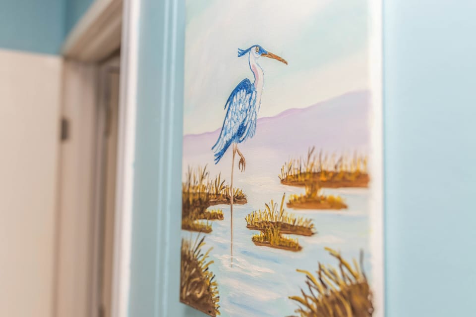 Coastal heron artwork adds a serene, beach-inspired touch