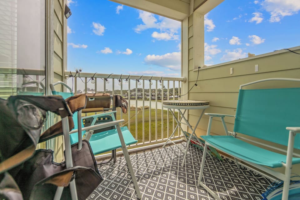 Covered balcony with cozy seating and peaceful open views