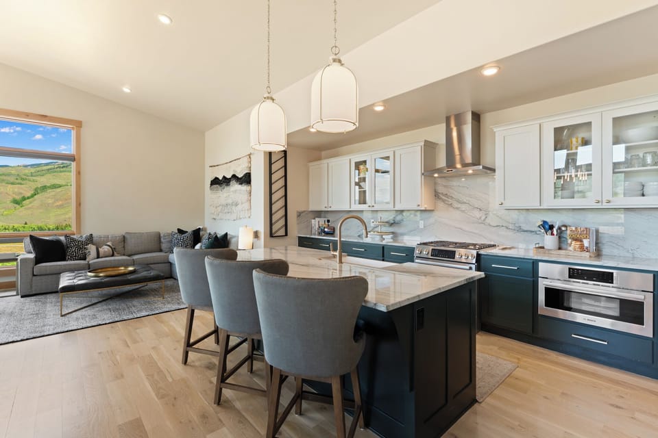 Gather around the island for morning coffee or meal prep, then unwind on the cozy sofa with stunning views just beyond your windows.