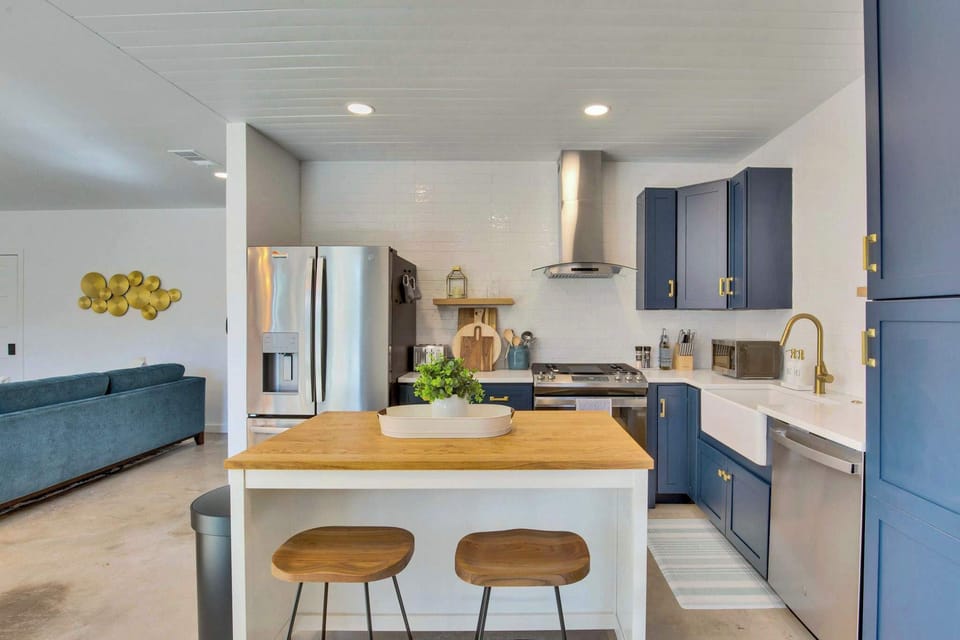 Navy cabinetry, butcher block counters, and gold fixtures — this kitchen is as gorgeous to look at as it is to cook in.