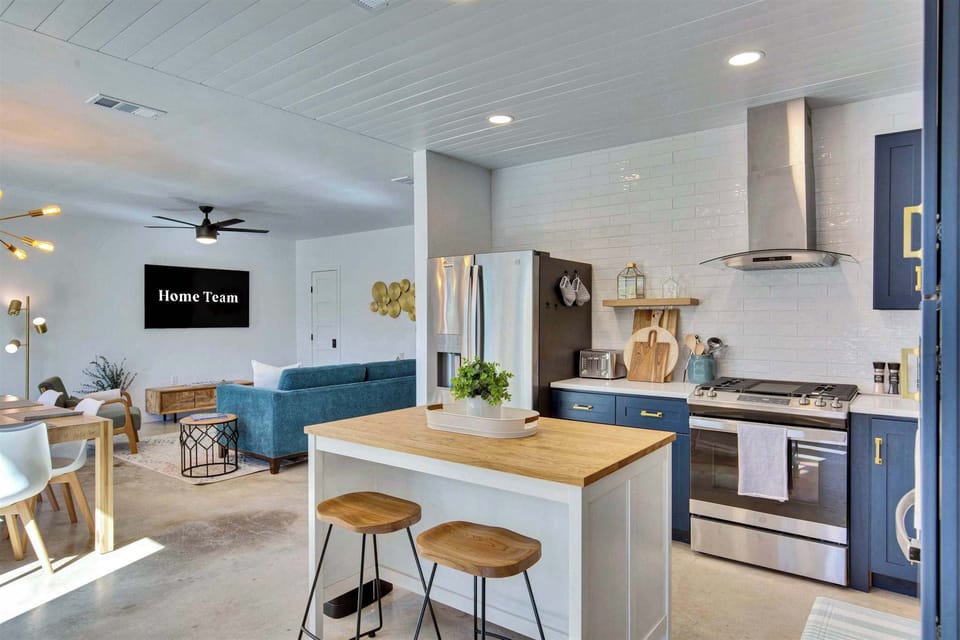 The kitchen island keeps the cook in the conversation — bar seating, butcher block counter, and an open flow into the living room make this space a natural gathering spot.
