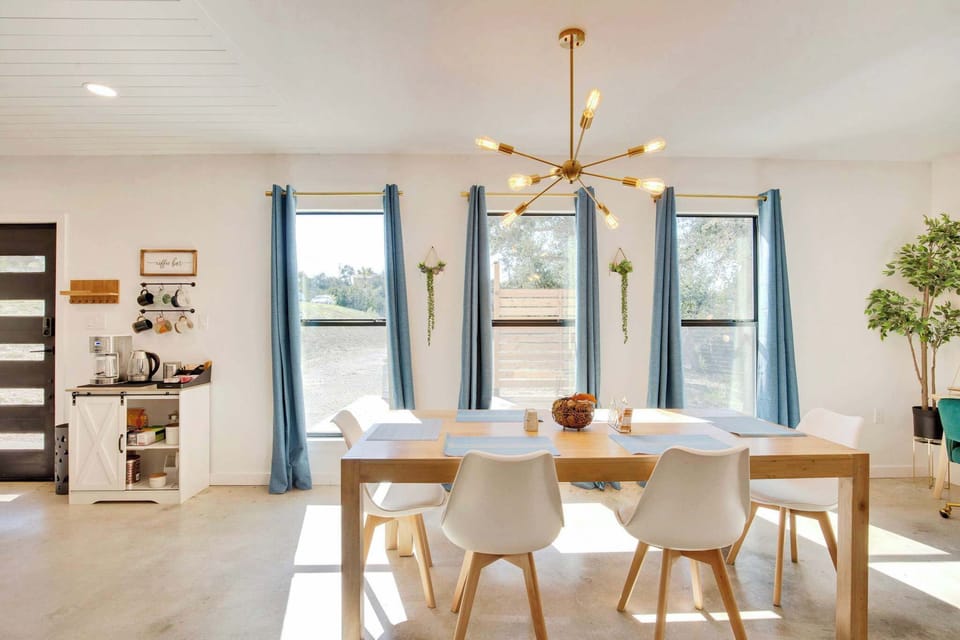  Sun-drenched and stylish — the dining area seats the whole group comfortably beneath a stunning gold chandelier.