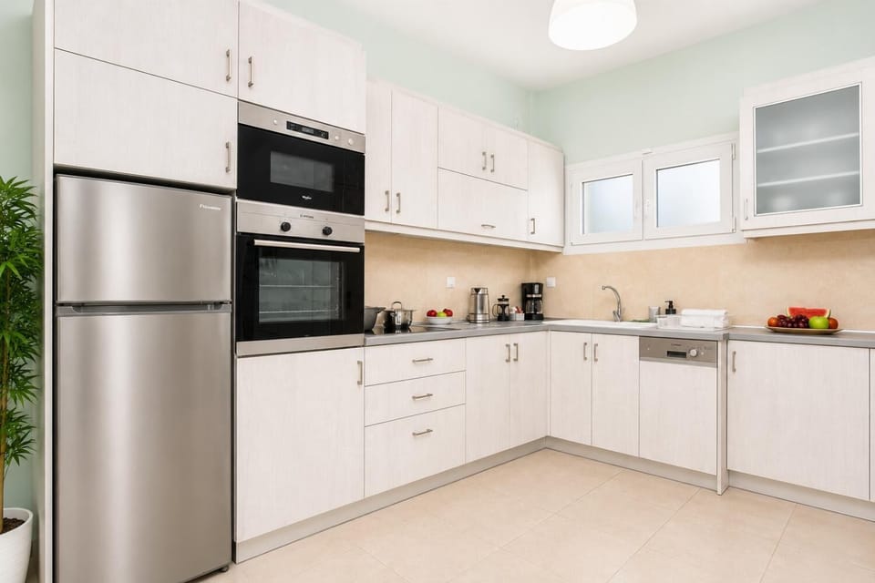 Bright fully equipped kitchen with modern appliances, light cabinetry, and a clean practical layout.