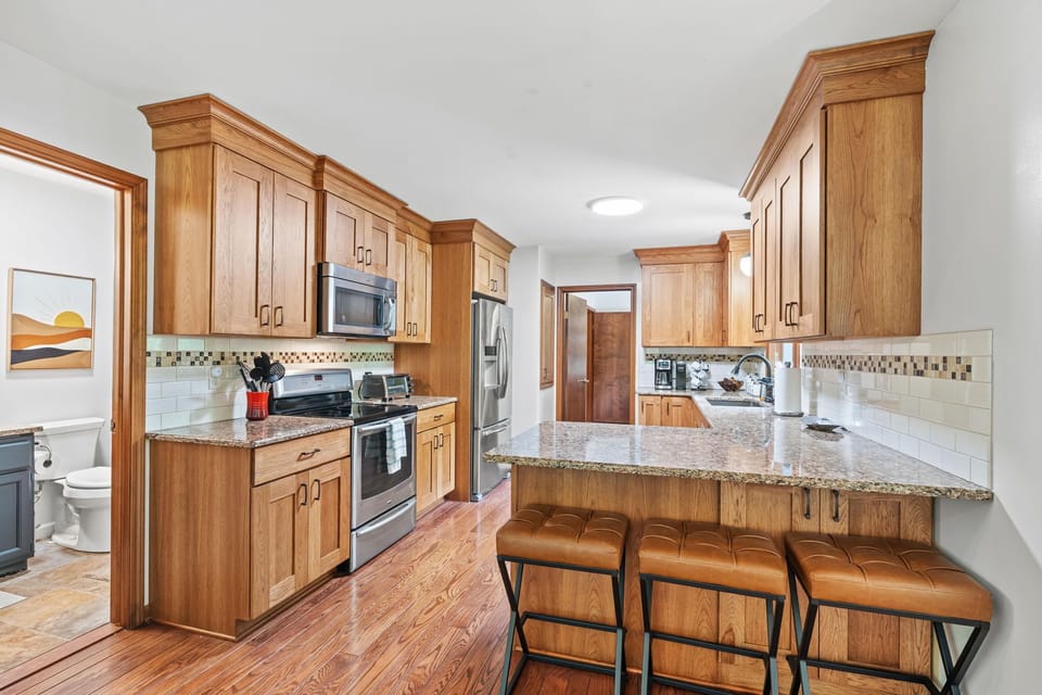 Bright updated kitchen with granite counters and breakfast bar seating