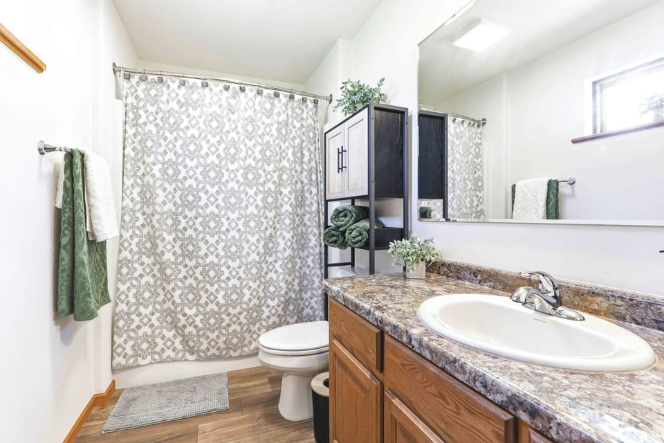 Start the day smoothly in a clean, inviting bath with fresh towels, warm wood accents, and plenty of vanity space.