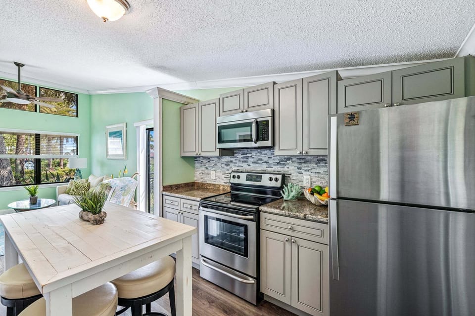 Cook with ease in the bright kitchen featuring stainless steel appliances and a spacious island.