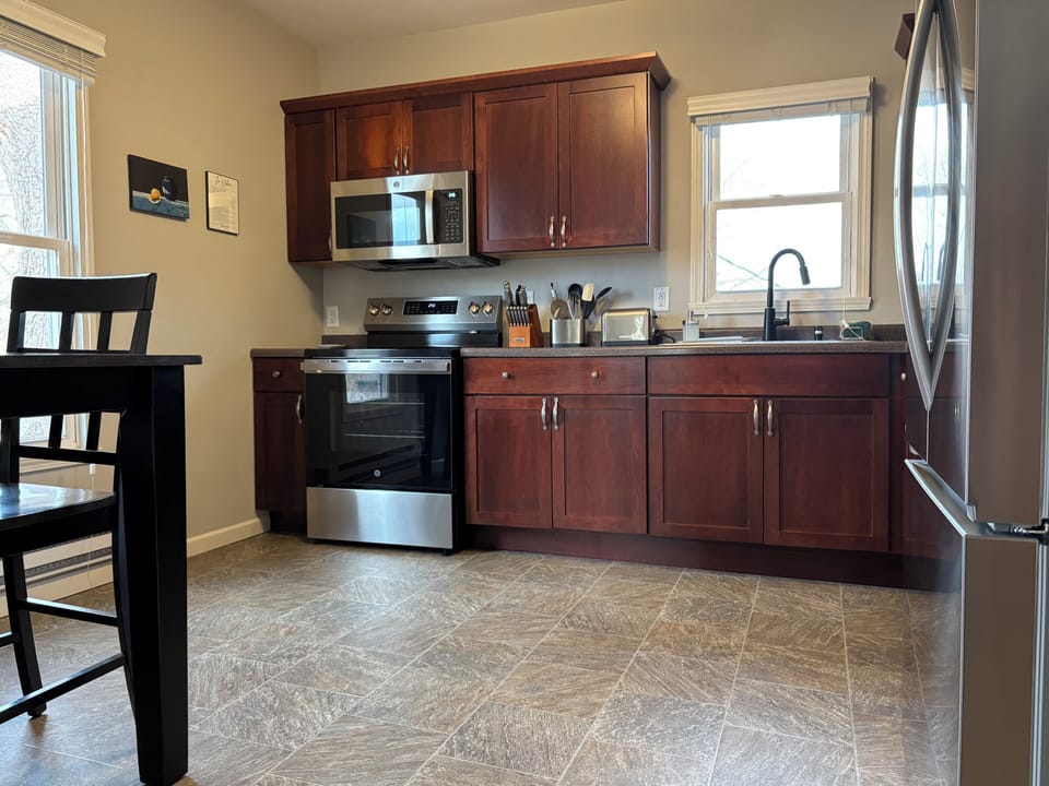 Upstairs cabinets are filled with kitchen supplies including mixing bowls, baking sheets, measuring cups, cutting boards, and food storage containers