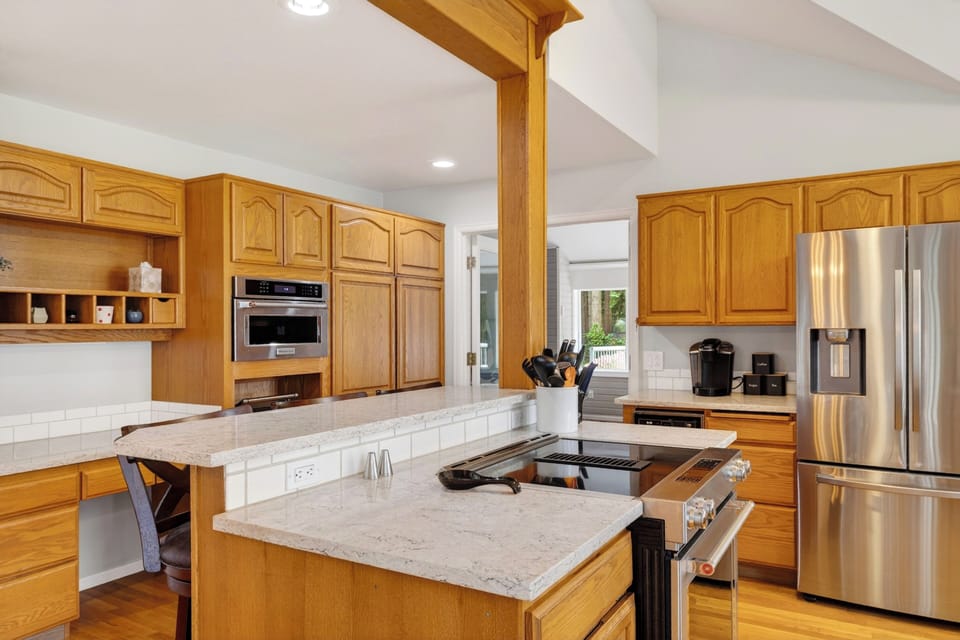 Well-equipped kitchen with generous counter space, stainless steel appliances, and a built-in workspace.
