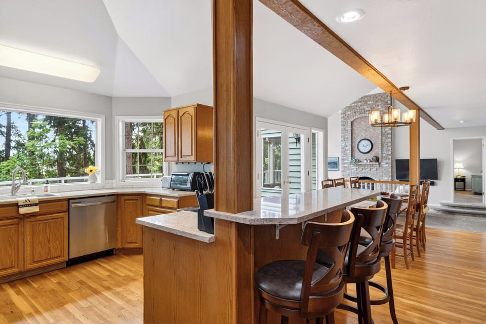 Full kitchen with bar seating, natural light, and easy flow into the dining area.