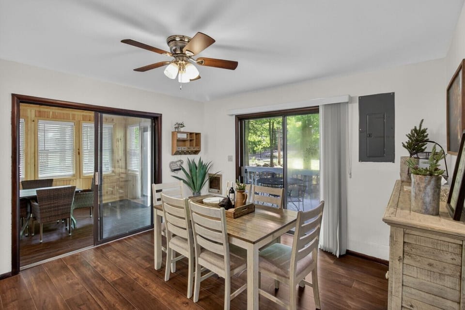Sunny dining area with sliding doors leading to the enclosed porch and outdoor space.