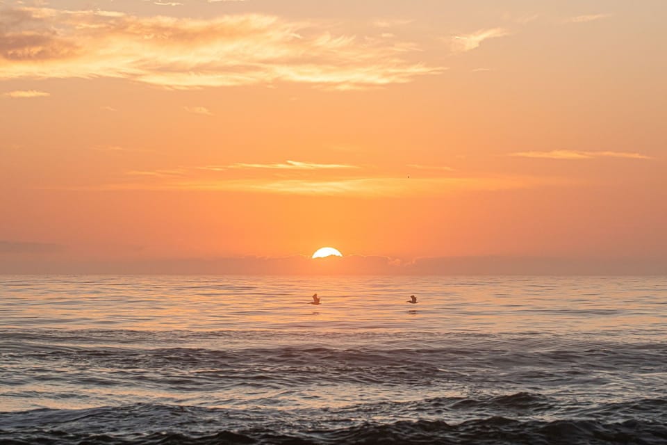 Peaceful ocean sunrise with glowing skies and gentle coastal waves