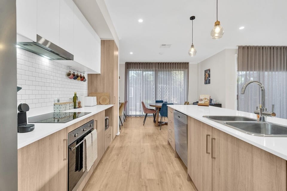 Chef`s kitchen with induction cooktop and subway tile splashback