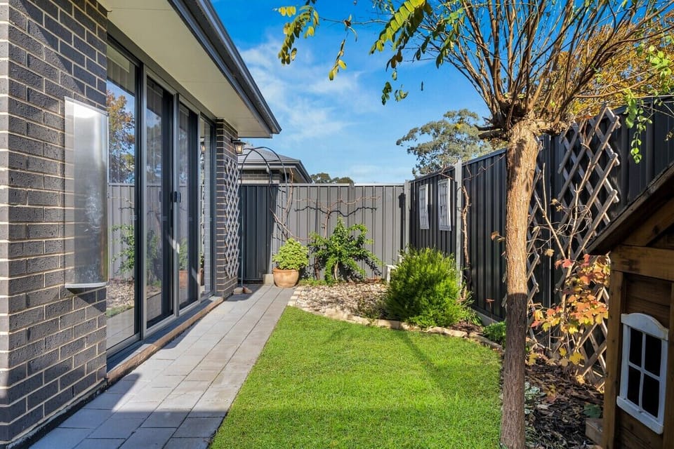 Private side garden with lawn and sliding door access