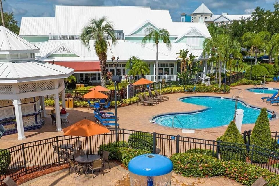 A spacious pool area surrounded by tropical landscaping.