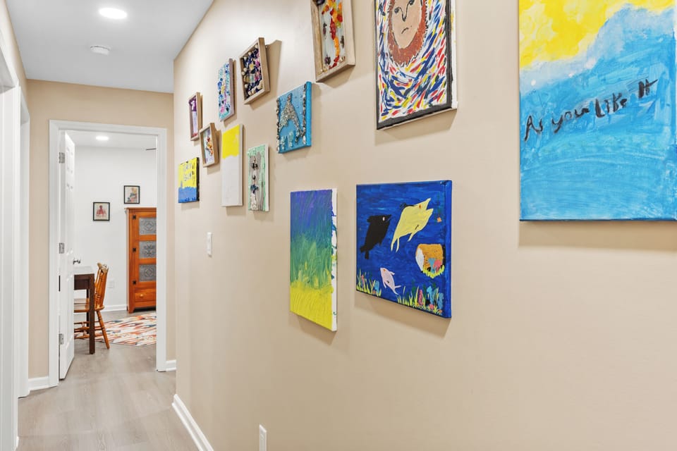 A collection of vibrant, colorful paintings lining the corridor.