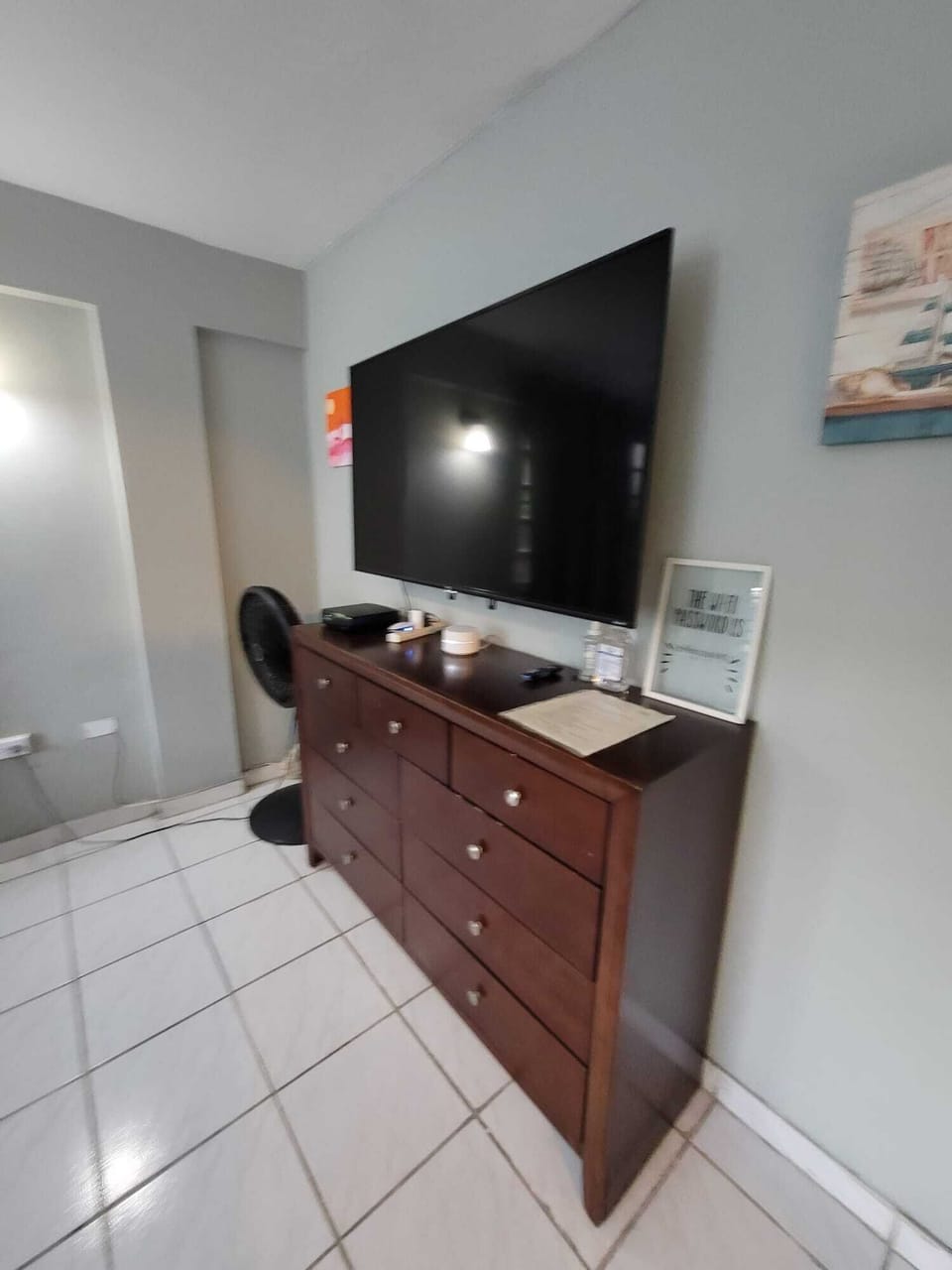 Large TV and spacious dresser in a clean, comfortable guest space