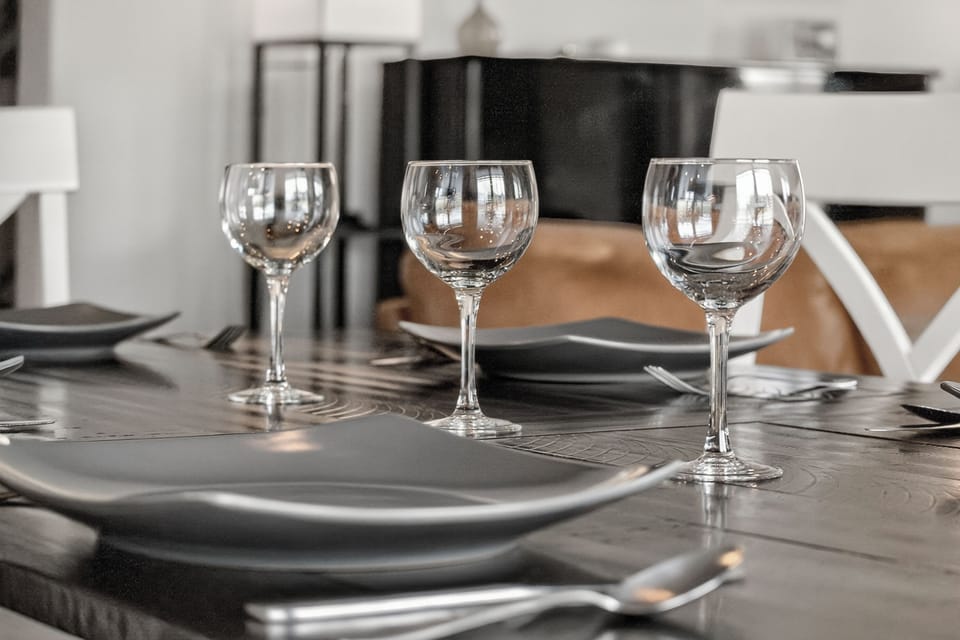 Enjoy meals at your elegantly set dining table, where every detail—from the polished glassware to the sleek tableware—invites you to savor every moment together.