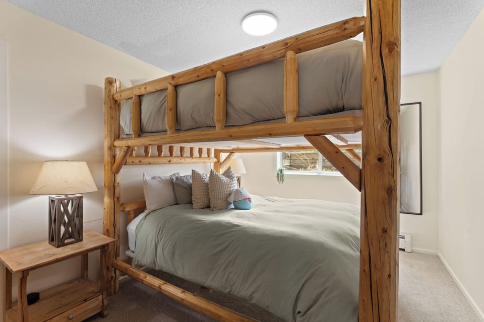 Relax into these cozy bunk beds with rustic timber frames and soft linens—perfect for kids or groups who want to share a charming, mountain-inspired retreat together.