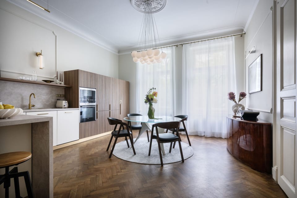 Bright designer kitchen-dining space with tall windows and elegant finishes