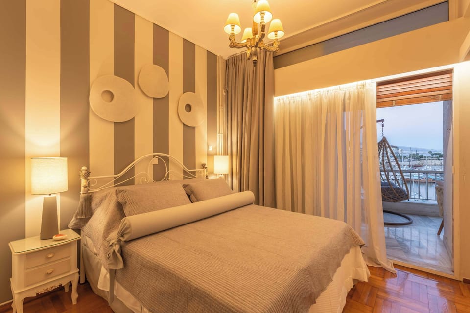 The bedroom opens toward the private balcony, offering a quiet connection to the marina and its yacht-lined views.