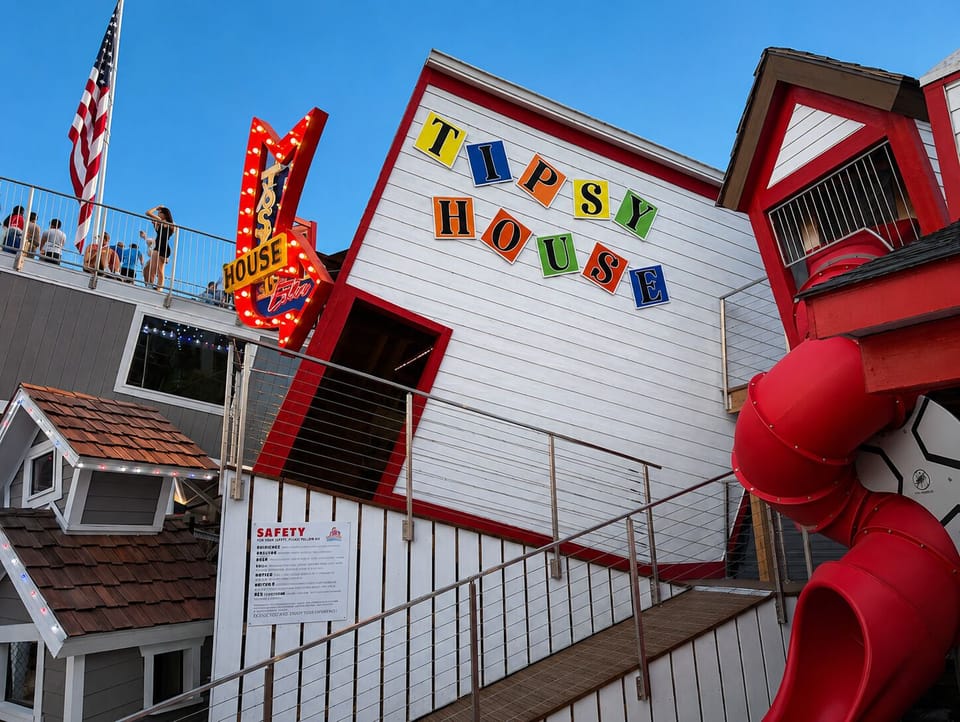 Whimsical Tipsy House attraction with rooftop views and a fun red slide