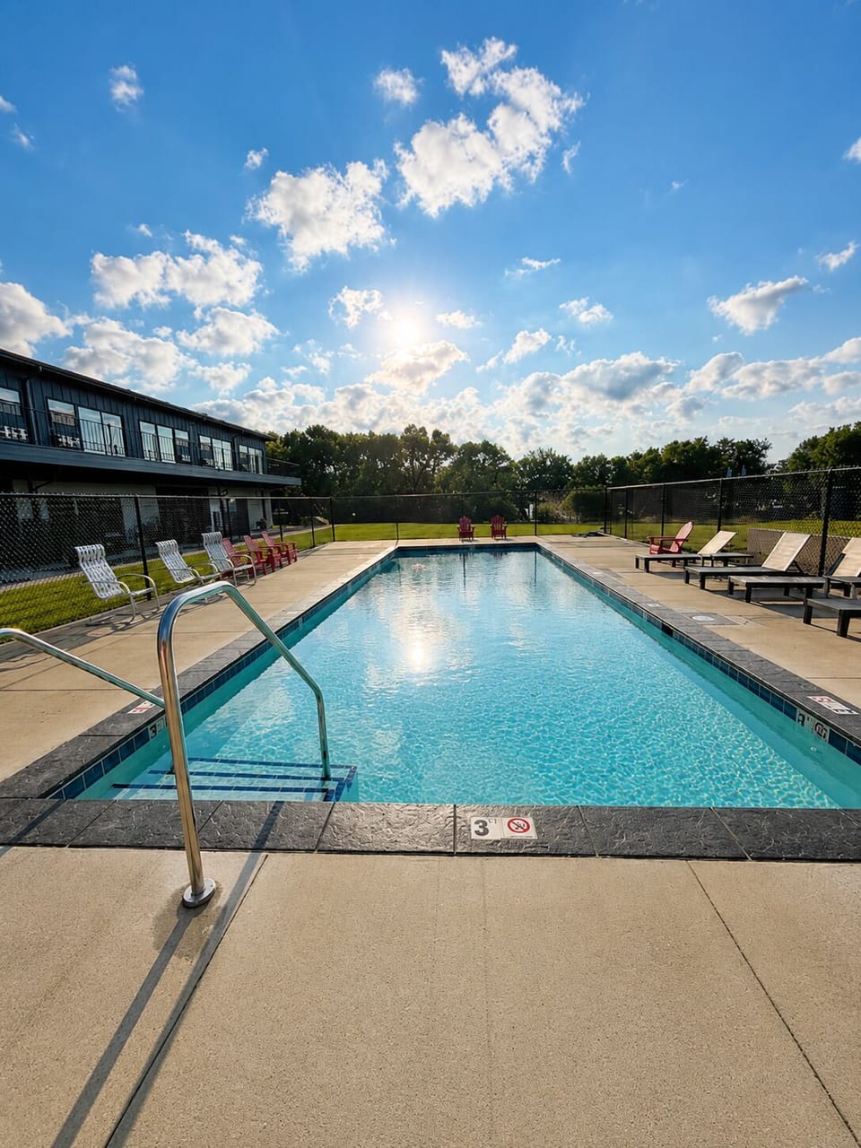 Sunny outdoor pool with lounge seating and a relaxing resort-style vibe