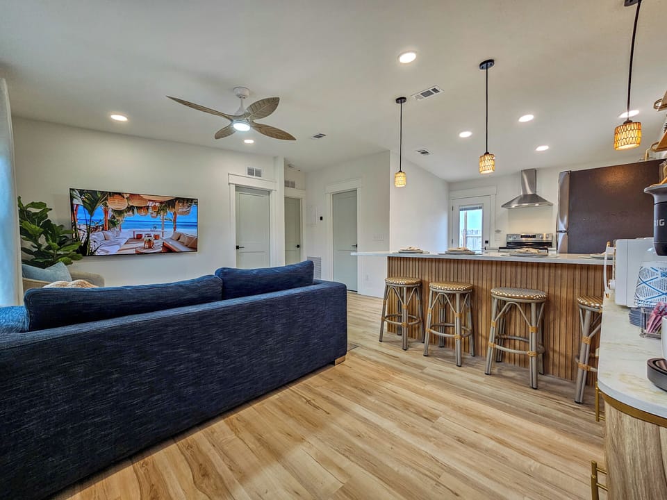 Bright open living space with a modern kitchen, Smart TV, and island seating.
