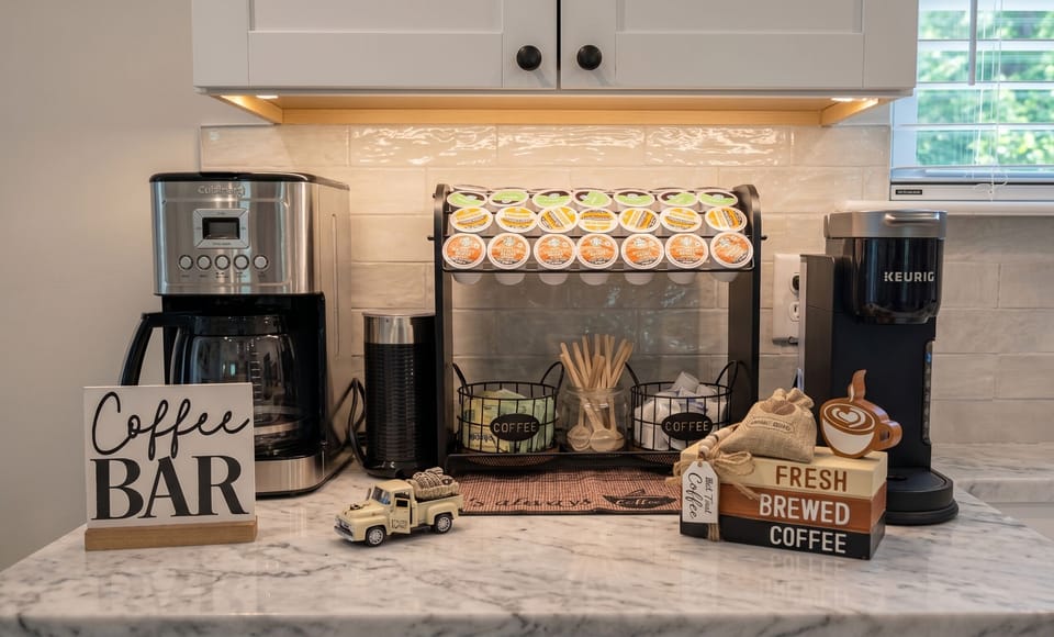 Fully stocked coffee bar with Keurig, drip coffee maker, milk frother, and assorted K-Cups.